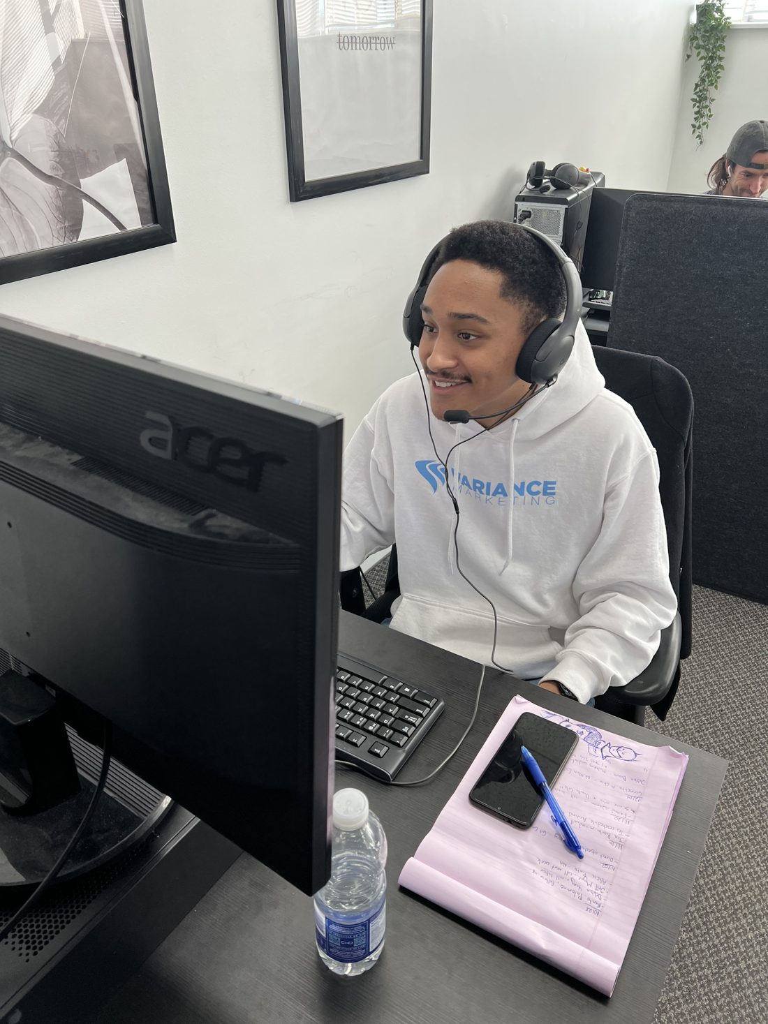 A Variance Marketing rep on a call, wearing a headset and a company hoodie